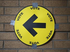 A sign directs voters to a polling station.