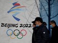 People walk past the Beijing 2022 Winter Olympics logo at the Shougang Park in Beijing. Perhaps it’s China’s apparent contempt for the human rights of the rest of the world that has prompted comparisons of these 2020 games and the notorious Berlin Olympics, Tom Mills writes. NOEL CELIS/AFP via Getty Images