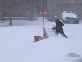 A west-end Kingston resident clears her driveway early Monday morning. Elliot Ferguson/The Kingston Whig-Standard
