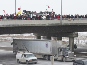 A few hundred people lined Bass Pro Mills Dr. over Hwy. 400 to cheer on truckers on Thursday, Jan. 27, 2022.