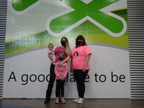 Bryttani Dickey and daughters Clementine (left) and Scarlett join BGC Airdrie Club manager of events and volunteer coordination Kathy Ritcher sporting some of the pink shirt styles that are being offered through the partnership with Sunshine Design. Photo by Riley Cassidy/The Airdrie Echo/Postmedia Network Inc.