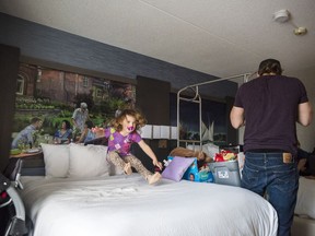 3-year-old Ameliah jumps on a hotel bed as her father Alec beings to unpack their belongings after moving out of transitional housing into a hotel provided by the Children's Aid Society. Monday in Belleville, Ontario. ALEX FILIPE