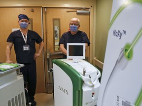 Drs. Meng Guan, left, and Ed Woods, stand behind laser machines used to treat urological conditions at Trenton Memorial Hospital. The GreenLight laser, right, is used to treat enlarged prostates.