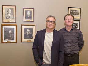 Bunnell Hitchon Insurance Brokers Inc. president Tony Silva (left) and executive vice-president Mike Moore stand in the boardroom among photos of the company's founders.
