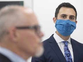 Ontario Education Minister Stephen Lecce looks over at Dr Kieran Moore, Ontario's Chief Medical Officer of Health at a news conference held in Toronto on Thursday, November 18, 2021. THE CANADIAN PRESS/Chris Young