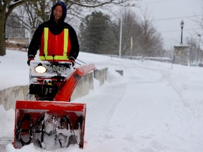 Scott Russell, of Brockville's public works department, finds the levity in a busy day as he clears the sidewalk by city hall on Market Street West on Monday afternoon. (RONALD ZAJAC/The Recorder and Times)