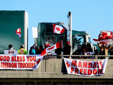 A transport truck passes "Freedom Convoy" supporters on the Stewart Boulevard overpass in Brockville on Friday morning. (RONALD ZAJAC/The Recorder and Times)