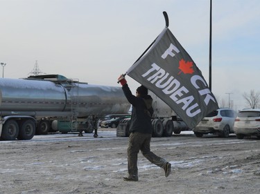 An individual, who was later seen attempting to direct traffic, runs through the rows of vehicles, screaming anti-mandate sentiments on Saturday January 29, 2022 in Cornwall, Ont. Shawna O'Neill/Cornwall Standard-Freeholder/Postmedia Network
