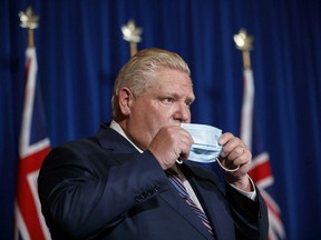 Ontario Premier Doug Ford puts his mask back on after speaking during a recent press conference at Queen's Park in Toronto.