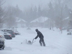 A man clears his west-end driveway Monday morning as a winter storm drops close to 50 centimetres of snow in the Kingston area, closing schools and shutting down city transit in Kingston, Ont. on Monday, Jan. 17, 2022. 
Elliot Ferguson/The Whig-Standard/Postmedia Network