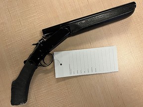 A sawed-off shotgun is displayed at Kingston Police Headquarters after police discovered it and a spring-loaded flick knife in a vehicle on Thursday.
