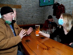 Greg Ball of Kingston playfully refuses a beer from server Alyssa Matheson at the Red House Downtown on King Street East in Kingston on Monday after the latest provincial pandemic lockdown order was lifted.