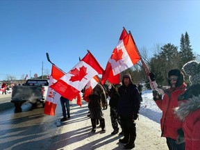 Supporters of the Freedom Convoy 2022 line Pinewood Park Drive in North Bay, Friday.