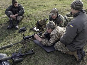 A Canadian soldier teaches Ukrainian military personnel how to operate Canadian small arms at the International Peacekeeping and Security Centre in Starychi, Ukraine, in 2015. File photo.