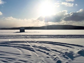 The solitary serenity of an ice fishing hut on Bark Lake as the sun goes down.