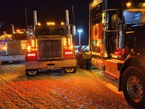 A row of trucks, all glowing and located in front of the Irving Big Stop to greet the Freedom Convoy as it rolled off Pembroke Ontario on the evening of January 28, 2022.