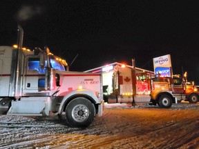 A row of trucks, all glowing and located in front of the Irving Big Stop to greet the Freedom Convoy as it rolled off Pembroke Ontario on the evening of January 28, 2022.
