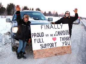 Pembroke residents and truck drivers Jenny Brotten and Dave Chaput put up their signs on Highway 17 near Pembroke on Jan. 28 to show their support for Freedom Convoy.