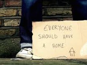 In this photo illustration, a person holds a sign saying everyone should have a home.