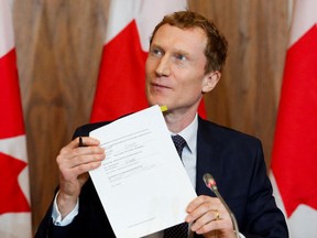 Minister of Crown-Indigenous Relations Marc Miller holds up a signed memorandum of agreement that outlines how and when Canada will share historical documents related to residential schools in Ottawa, Jan. 20, 2022.

REUTERS/Patrick Doyle