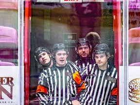 GAME FOR THE GAME On-ice officials at Friday night's Soo Greyhounds and Flint Firebirds hockey game prepare to take to the ice for the start of the second period of action.  The game was tied at the end of regulation time with the Firebirds winning the contest in overtime. Referees Mac Nichol and Ryan Harrison (foreground) wait patiently along with line officials Marcus Policicchio and Josh Houslander. BOB DAVIES