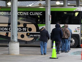 People line up to get a COVID-19 vaccine dose from one of Ontario's mobile bus-based clinics on Monday, Jan. 10, 2022 in Petrolia, Ont. Terry Bridge/Sarnia Observer/Postmedia Network