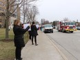 Bluewater Health workers are shown in this file photo holding signs outside the Sarnia hospital in March 2020 while emergency vehicles paraded by in support of health care workers early in the pandemic. Fire, police and ambulance vehicles are set to repeat the parade Tuesday at 2 p.m.