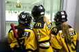 A trio of minor hockey players watch the action while waiting to hit the ice. (Free Press files)