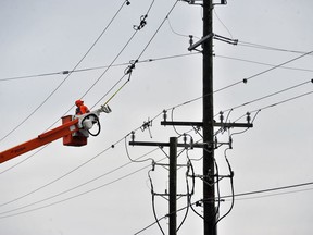 A lineman with Hydro One addresses a burnt-out pole issue on Blue Line Road east of Simcoe Wednesday arising from high winds. There were several power outages in the area Wednesday afternoon, including one in the Port Dover area impacting more than 4,000 customers. MONTE SONNENBERG