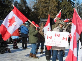 A participant is surrounded by Canadian flags on Saturday, Jan.  29 at the Norfolk Convoy Support 2022 rally held in Wellington Park in Simcoe.  MICHELLE RUBY/THE EXPOSITOR