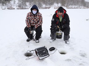 Jason Lavallee, left, and Lance Smith braved the elements to try their luck at ice fishing at Lake Laurentian in Sudbury, Ont. on Wednesday January 5, 2022. John Lappa/Sudbury Star/Postmedia Network
