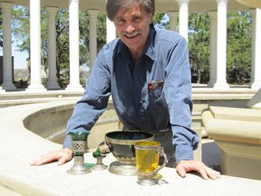 Antique hobbyist and first-time author Peter Churan poses with a set of ancient glassware he found in a local flea market 17 years ago. Supplied