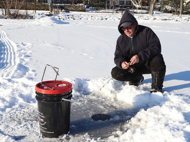 Mark Henry tries his luck at fishing at Ramsey Lake in Sudbury, Ont. on Friday January 7, 2022. There is a good chance of snow on Saturday, with a hig of -2 degrees C. Similar weather is expected for Sunday. John Lappa/Sudbury Star/Postmedia Network