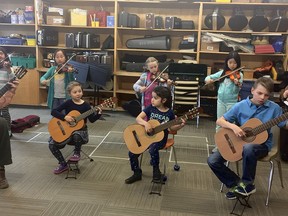Matt Gould, Cambrian guitar teacher, left, and Beth Schneider-Gould, principal violin of the Sudbury Symphony Orchestra, perform with the Suzuki group during a music class with RL Beattie.  Provided