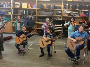 Matt Gould, Cambrian guitar teacher, left, and Beth Schneider-Gould, principal violin of the Sudbury Symphony Orchestra, perform with the Suzuki group during a music class with RL Beattie. Provided