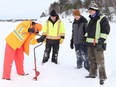 Tate Kennie, left, uses an auger to cut a hole in the ice on Ramsey Lake as his friends, Nolan MacNeal, Nolan Campbell and Mike Elliott look on in Sudbury, Ont. on Friday January 21, 2022. The guys were looking for a good location to go ice fishing. John Lappa/Sudbury Star/Postmedia Network