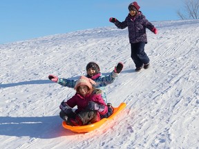 Charlotte, 8, back, chases after Sophia, 7, and Georgia, 5, as they slide down a hill at Robinson Playground in Sudbury, Ont. on Wednesday January 26, 2022. John Lappa/Sudbury Star/Postmedia Network