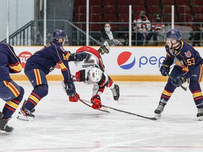 Ottawa 67’s Brady Stonehouse gets tripped up by Barrie Colts’ Grayson Tiller (left) as Beau Jelsma (53) looks on. Barrie won the game 5-2. VALERIE WUTTI photo