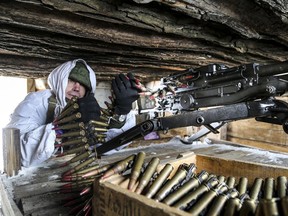 A serviceman checks his machine-gun in a shelter on the territory controlled by pro-Russian militants on the front line with Ukrainian government forces near Spartak village in Yasynuvata district of Donetsk region, eastern Ukraine, Jan. 27, 2022.