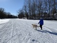 A woman walks her dog on the Sydenham River at Dresden, in a photograph taken Feb. 9, 2021. The OPP is reminding anglers and others in areas like Mitchell's Bay and Rondeau, as well as local rivers and streams, to always keep safety in mind and be prepared for changes in conditions. Peter Epp/Postmedia