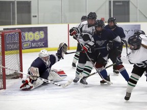Mustangs goalie Arenn Osadzuk makes an acrobatic save to stop Avery Rowe's (No. 9) shot in the second period as the St. Mary's Mustangs shut out the Grey Highlands Lions 2-0 in Bluewater Athletic Association senior girls hockey at the Julie McArthur Regional Recreation Centre on Nov. 29, 2018 in Owen Sound. Greg Cowan/The Sun Times