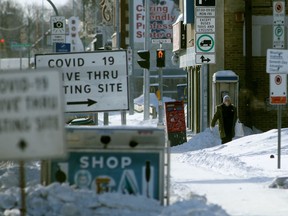 COVID-19 testing site signs near the sidewalk on Main Street in Winnipeg on Friday. Jan. 7, 2022.