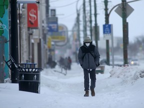 A person wears a mask while walking along a sidewalk in Winnipeg on Saturday, Jan 8. 2022.