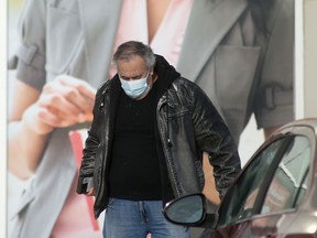 A person wears a mask while walking in a parking lot in Winnipeg on Thursday, Jan. 13.