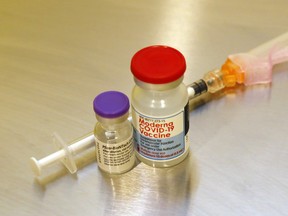 Vials of the Pfizer-BioNTech (left) and Moderna vaccines stand next to a syringe. Vaccination has and will continue to play a key role in how quickly COVID-19-related hospitalizations and the pandemic itself subside, experts say.