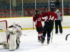 St. Charles College Cardinals players celebrate a goal against the Bishop Alexander Carter Catholic Secondary School Golden Gators in SDSSAA exhibition hockey action at Garson Arena in Garson, Ontario on Saturday, October 23, 2021.