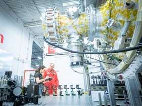 Workers with General Fusion's P13 plasma injector, the world's largest most powerful plasma injector, at the company's Vancouver lab.