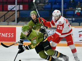 Michael Podolioukh of the North Bay Battalion goes to the ice in front of Kalvyn Watson of the Sault Ste. Marie Greyhounds as the Troops' Brandon Coe watches in Ontario Hockey League action Thursday night. Watson scored twice but it wasn't enough as the Hounds lost 5-4 in overtime to the Battalion on Friday night.