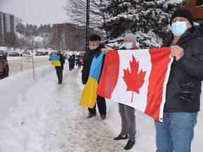 Displaying Canadian and Ukraine flags are, from left, Peter Zloczewski, Yurii Shcherbiuk and Gregory Babiak.