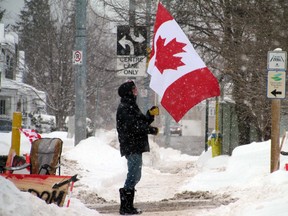 A lone protestor stands on Huron Street Thursday afternoon, directly across the street from the entrance to the International Bridge. JEFFREY OUGLER/POSTMEDIA
